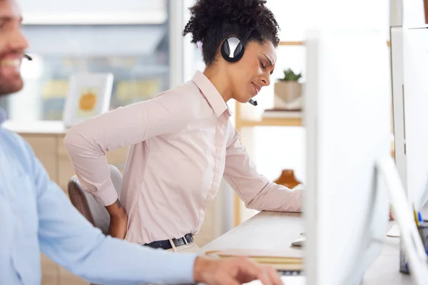Back pain, stress or black woman in call center with a spine injury, burnout or muscle problem at office desk. Callcenter, emergency or sales agent frustrated with uncomfortable bad chair or backache.
