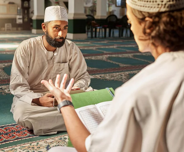 Quran, muslim and mosque with an imam teaching a student about religion, tradition or culture during eid. Islam, book or worship with a religious teacher and islamic male praying together for ramadan.