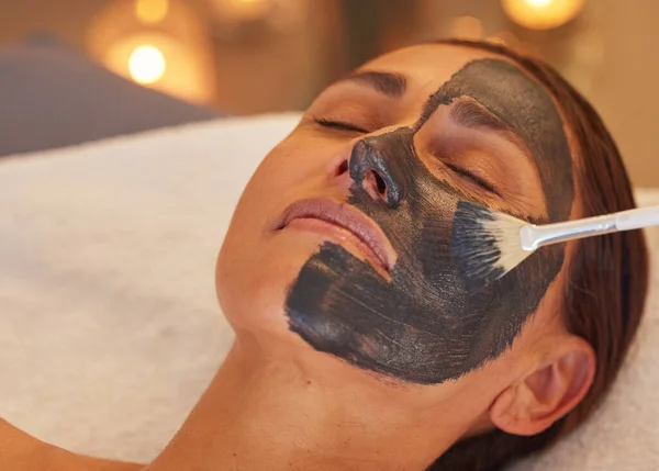 Spa, woman and charcoal face mask, skincare and luxury for health, wellness and clear skin. Beauty, cosmetics and girl with organic facial, detox and natural care for confidence or treatment to relax.