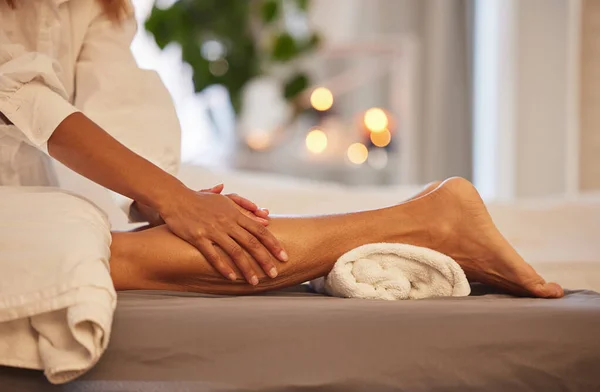 Spa, hands and legs massage for relax, health and wellness at luxury resort. Zen, physical therapy and woman or female .therapist massaging leg of person on table for skincare, body care and beauty