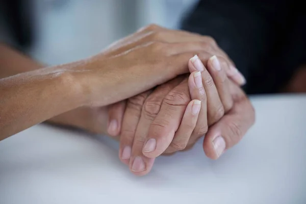 Hands, support and trust with a business woman consoling or comforting a man employee in the office at work. Help, love and hope with a female and male employee holding hands in comfort or support.
