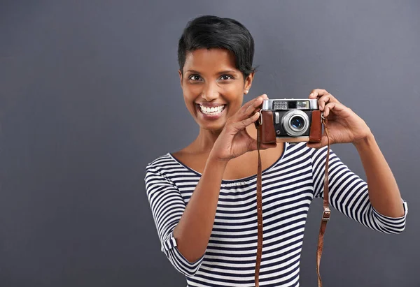 Say cheese. Portrait of a happy young woman standing on a gray background