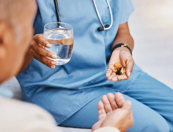 Pills, water and hands of nurse with patient in nursing home for wellness, healthcare and prescription. Doctor, medical care and health worker with vitamins, supplements and medication treatment.