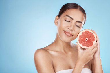 Skincare, grapefruit and happy wellness woman satisfied with vitamin c body care glow treatment. Aesthetic, detox and natural cosmetic model in blue studio with beauty marketing mockup