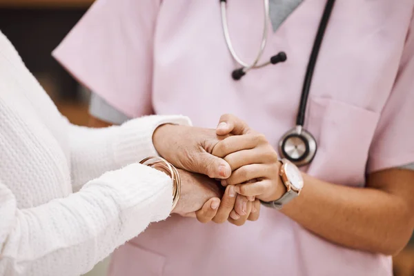 Support, empathy and nurse holding hands with patient for compassion, trust and comfort from medical results. Insurance, healthcare and female doctor with senior woman for sympathy in consultation.