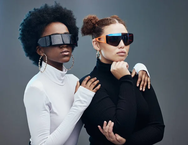 Fashion, futuristic and cyberpunk with women in sunglasses, young and trendy designer brand with gen z youth. Marketing, diversity and future style with vision and edgy against studio background.