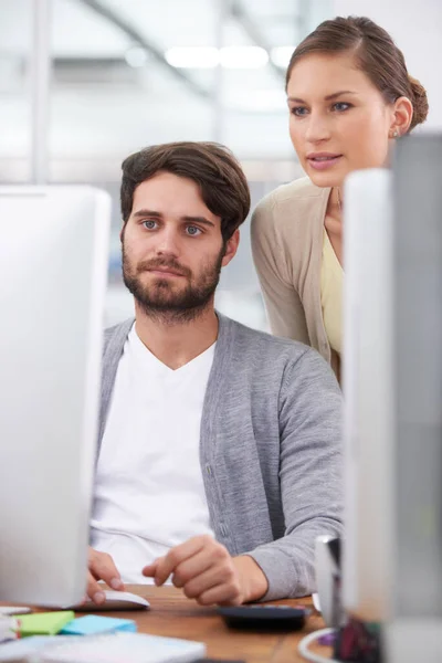 Going over the final touches. a young businesswoman looking over her colleagues shoulder at his computer