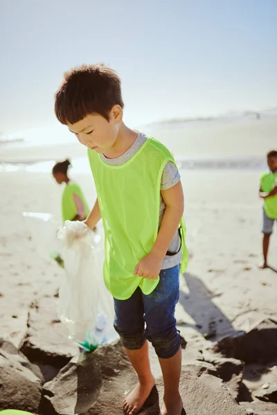ビーチで汚染がある子供たちは 環境に優しいボランティアです 持続可能性 リサイクル アジアの少年は ビーチの砂の上にゴミやプラスチックを拾う 廃棄物を削減 — ストック写真