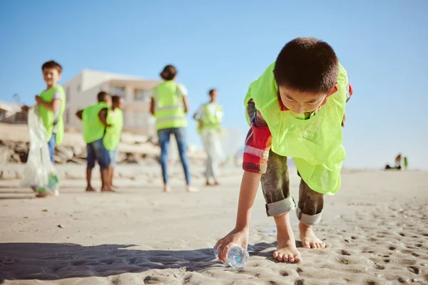 Environment, cleaning and children with plastic on beach for clean up dirt, pollution and eco friendly volunteer. Sustainability, recycle and kids reduce waste, pick up trash and bottle on beach sand.