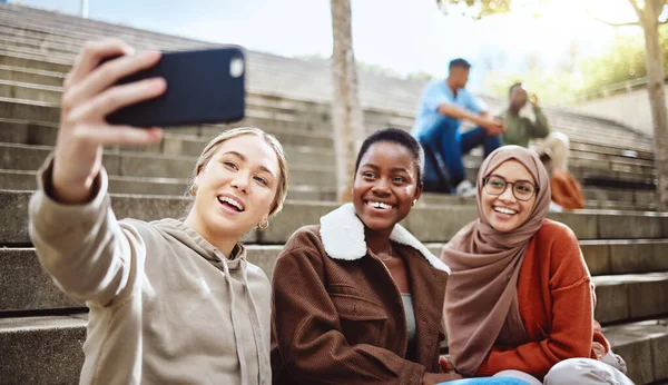 Women, diversity or phone selfie on university stairs, school steps or college campus bleachers for social media or profile picture. Smile, happy or bonding students on mobile photography technology.
