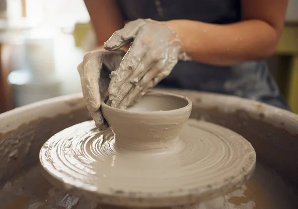 Hands, clay and pottery with a woman designer working in a studio or workshop for art, design and ceramics. Creative, sculpture and wheel with a female artist at work as a potter or ceramic artisan.