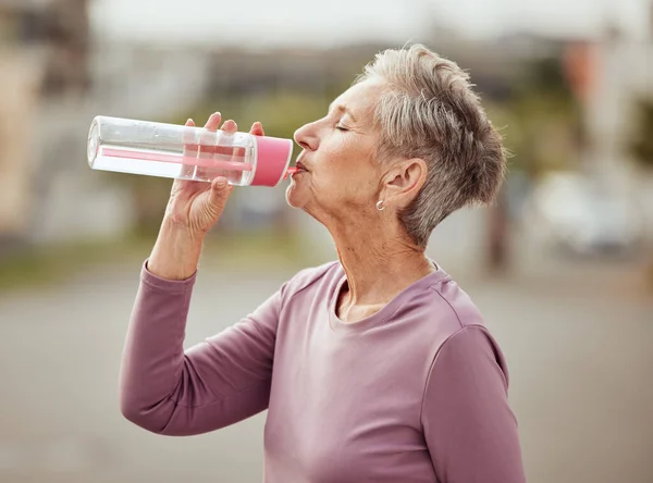Fitness, runner or senior woman drinking water with sports goals resting or relaxing on break. Healthy, tired or thirsty elderly lady drinks natural liquid in cardio workout, training or exercise.
