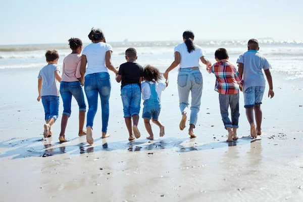 波による異人種間の多様性との休暇 太陽と結合のための大きな家族 ビーチウォークと水 海によって休日の連帯 ケアと愛のための幸せな家族 母と手を握って — ストック写真