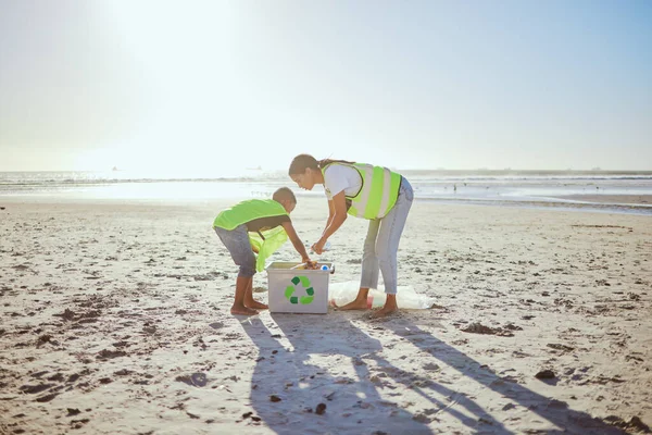 持続可能性 緑の環境や環境に優しい海のためのビーチクリーニングサポートで子供を持つリサイクル プラスチックや女性 母またはボランティアの家族は 汚染や地球の日のために海の箱で助けます — ストック写真