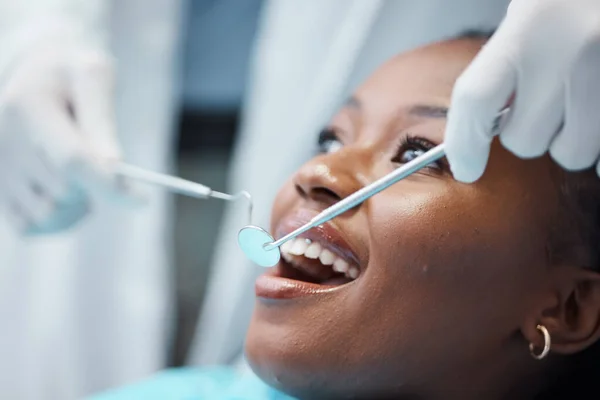 Black woman, mouth and face with dentist, tools in hands and dental, teeth check for healthcare with tooth decay. Tooth surgery, orthodontics and smile, teeth whitening, closeup and Invisalign.