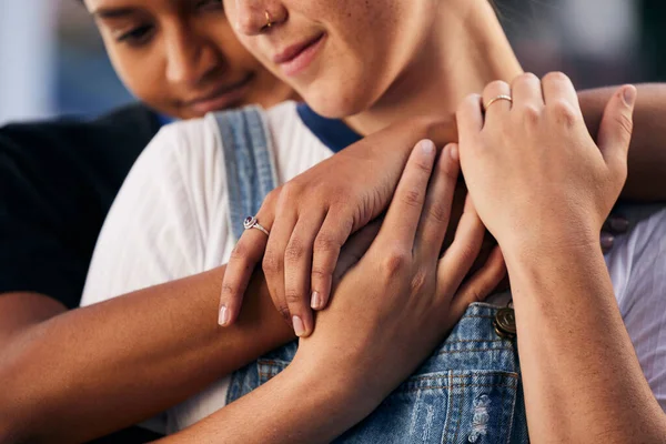 Hands, love and lgbt with a woman couple hugging outdoor for romance, dating or non binary affection. Hug, date and gay with a gender neutral female and partner sharing an intimate moment together.