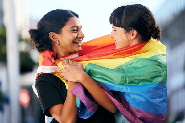 Lgbtq, happy women and flag for pride, equality and protest of love, support and care in city. Gay, lesbian and couple of friends with rainbow identity, gen z festival and human rights freedom event.