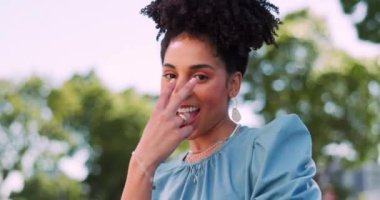 Face, fun and gesture with a black woman pointing while standing outdoor and laughing or joking. Laugh, humor and joke with a female outside in the park gesturing I see you with a hand sign.