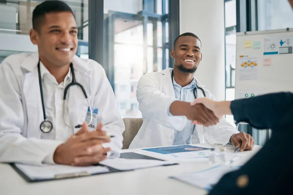 Doctor, handshake and meeting with patient, smile and greeting for vaccination education, talk or help. Black man, doctors and shaking hands with client for wellness, healthcare or medicine in clinic.