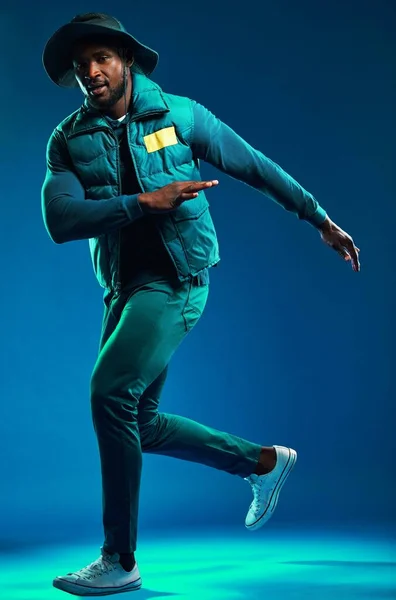 Fashion, neon and portrait of black man on blue background with cool, trendy and stylish outfit. Creative style, urban clothing and male fashion model in studio with designer, modern and edgy clothes.
