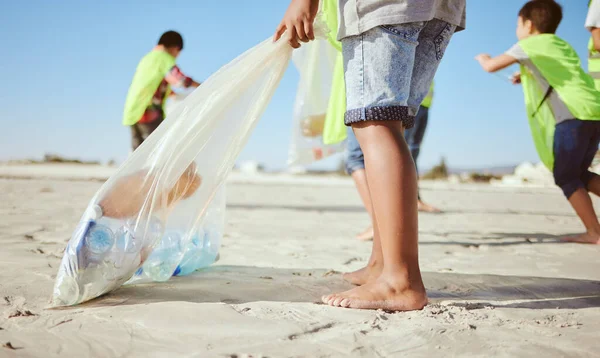 stock image Children, legs or plastic bottles in beach clean up, climate change collection or environment sustainability recycling. Kids, diversity or students in cleaning waste management or community service.