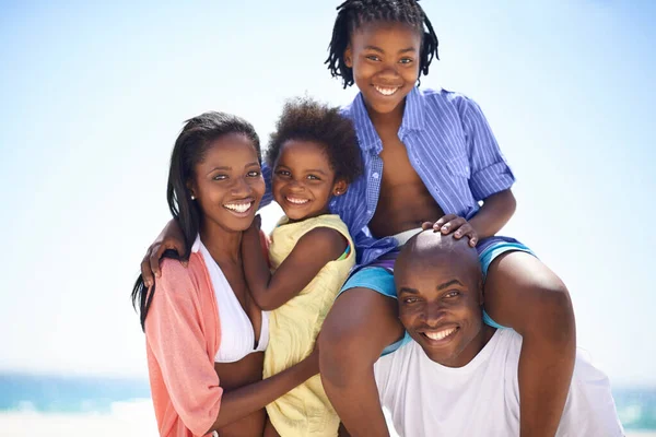 Loving family have a great time on the beach. An african american family enjoying a day out on the beach