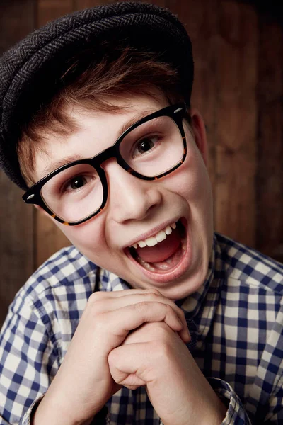 Filled with enthusiasm. Young boy in retro clothing wearing spectacles with an excited expression