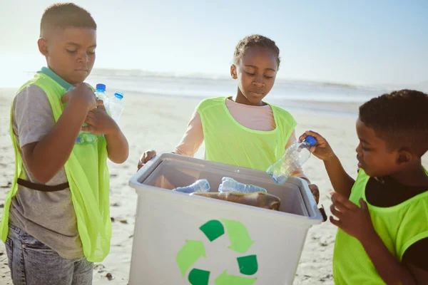 Group of children cleaning beach or recycling plastic for education, learning or community help in climate change project, ngo and charity. African friends with recycle box and teamwork on earth day.