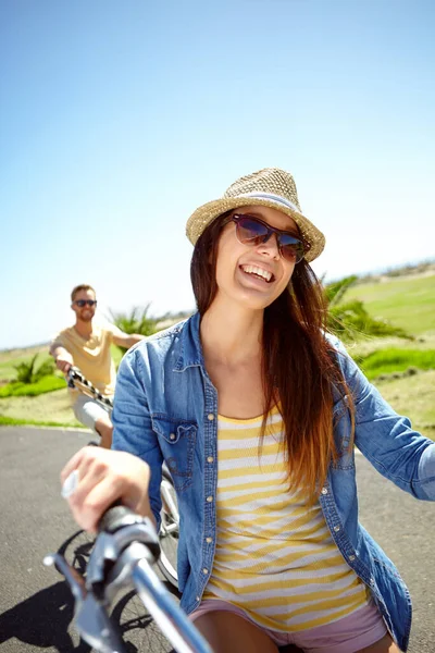 Cycling, travel and woman on couple vacation, summer holiday fun outdoor riding on blue sky background. Bicycle, smile and happy date with partner on bike ride, freedom and happiness with love in sun.
