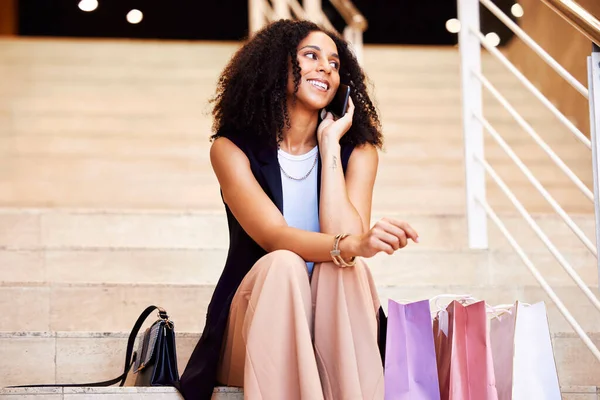 Smile, shopping phone call and woman at a mall for a sale, fashion and retail with a phone. Ecommerce, happy and thinking girl on a mobile conversation with shopping bags after a shopping spree.