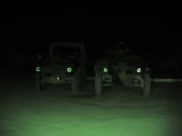 Covert operations. two military vehicles viewed through night vision goggles