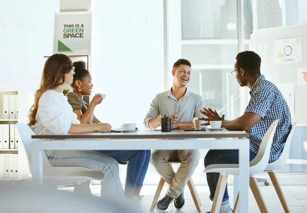 Group of diverse businesspeople having a meeting in an office at work. Cheerful businesspeople talking and laughing during a workshop. Businesspeople planning together.