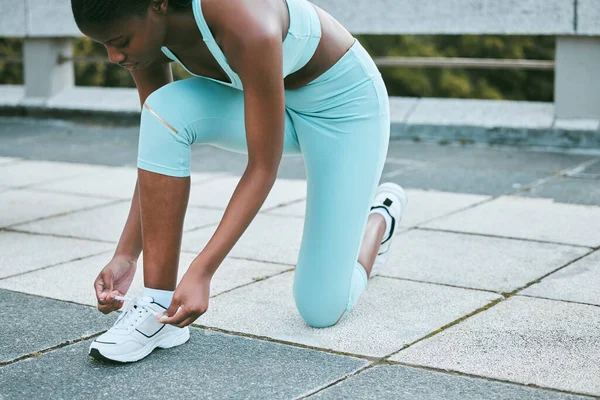 一个适合年轻的非洲裔美国女人在外面锻炼时系鞋带 黑色运动员紧固运动鞋 以适应舒适的身体 并防止在训练时绊倒 — 图库照片