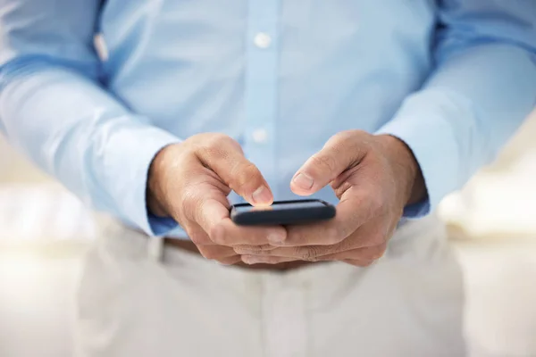 Id love to hear more about this. a businessman using his smartphone to send a text message
