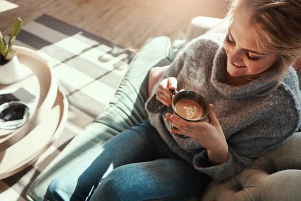 Woman, coffee and relax smile on sofa in living room for calm, peace and happy quality time. Female, drinking warm tea and happiness or lifestyle wellness, morning routine and rest on couch in home.