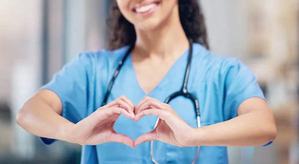 Doctors dedicate their lives to taking care of others. an unrecognizable doctor making a heart gesture with their hands at a hospital