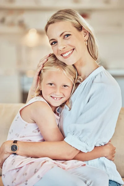 Portrait of mother hugging her daughter. Caucasian woman embracing her child. Little girl being affectionate with her parent. Mother and daughter holding one another. Loving woman hugging her kid.