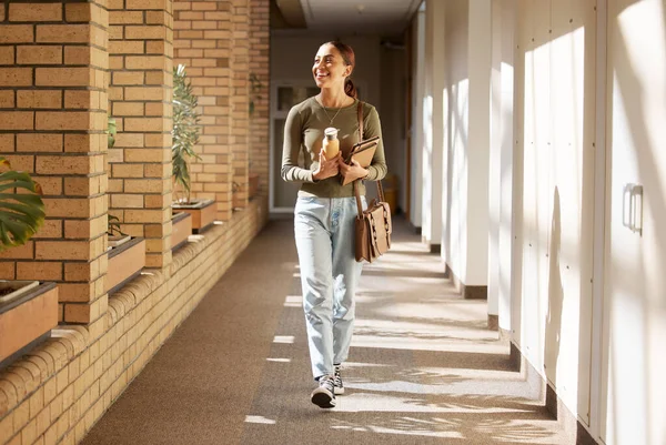 Woman, student and university hallway with a person walking ready for learning and study. Smile, college and back to school happiness of a female tutor on campus going to class happy and alone.