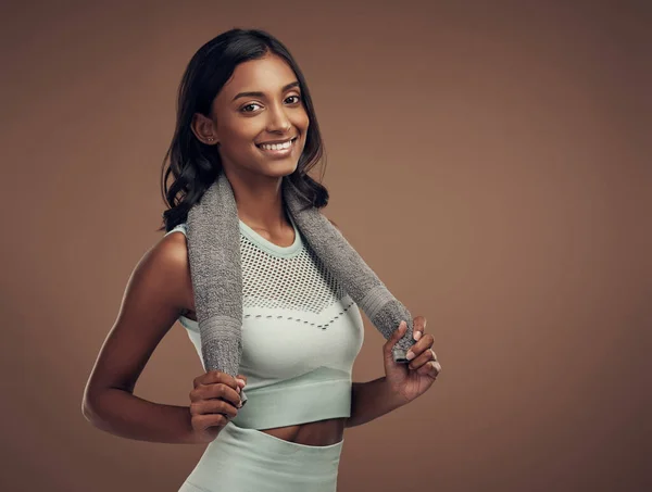 Stock image Im ready to workout. an attractive young woman standing alone in the studio and posing with a towel after working out