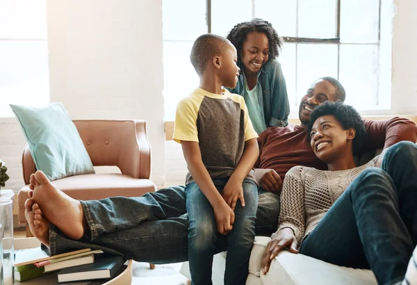 Black family children, happy parents or relax African people smile together, bond and enjoy quality time. Happiness, love and young youth kids, easy father and mother lounge on home living room sofa.