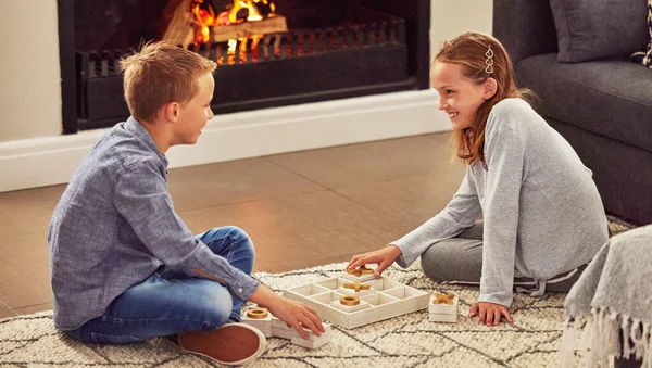 Prepare to lose. an adorable little girl bonding with her brother in the living room at home while playing games