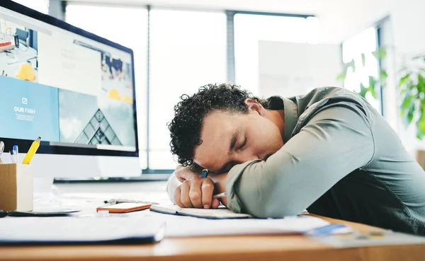 Short naps are essential to being productive. a young businessman taking a nap in an office