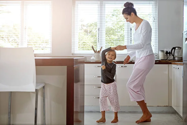 Kitchen dance, mom and girl in the morning at home with happiness dancing together. Mom, child and mama care holding hands with a young kid in a house happy about funny family with a smile.