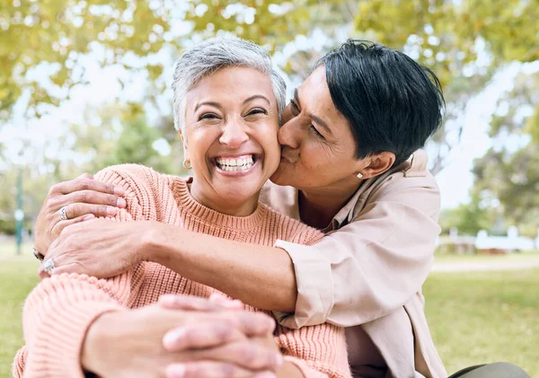 Couple of friends, portrait or cheek kiss in nature park, grass garden or relax environment in support, love or retirement. Smile, happy or senior women in elderly bonding, fun embrace or trust hug.
