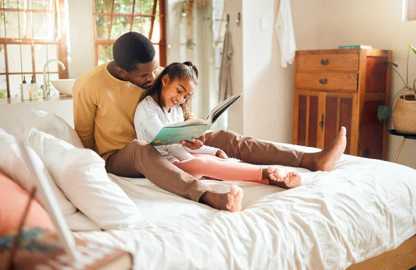 Black family, reading book and bedroom with father and child together for story time. Man or dad and girl together in home bedroom for bonding, learning and education or knowledge with fantasy.
