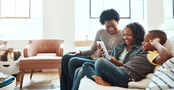Family with tablet, streaming and relax at family home together, spending quality time together with technology. Black people, mother and children on sofa with device, internet wifi and social media.