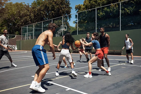 Theres nothing better than playing with your friends on the court. a group of sporty young people playing basketball on a sports court