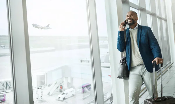 Businessman, phone call and luggage waiting at airport for travel, work trip or plain journey to country. Happy black man, employee or person with smile for communication before flight on smartphone.