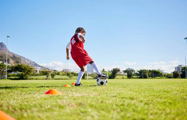 Soccer girl child, field and training for fitness, sports and balance for control, speed and strong body from low angle. Female kid, fast football dribbling and exercise feet on grass in Cape Town.