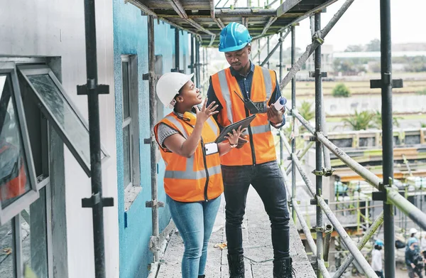 Implementing the right software can help facilitate a more efficient jobsite. a young man and woman using a digital tablet while working at a construction site